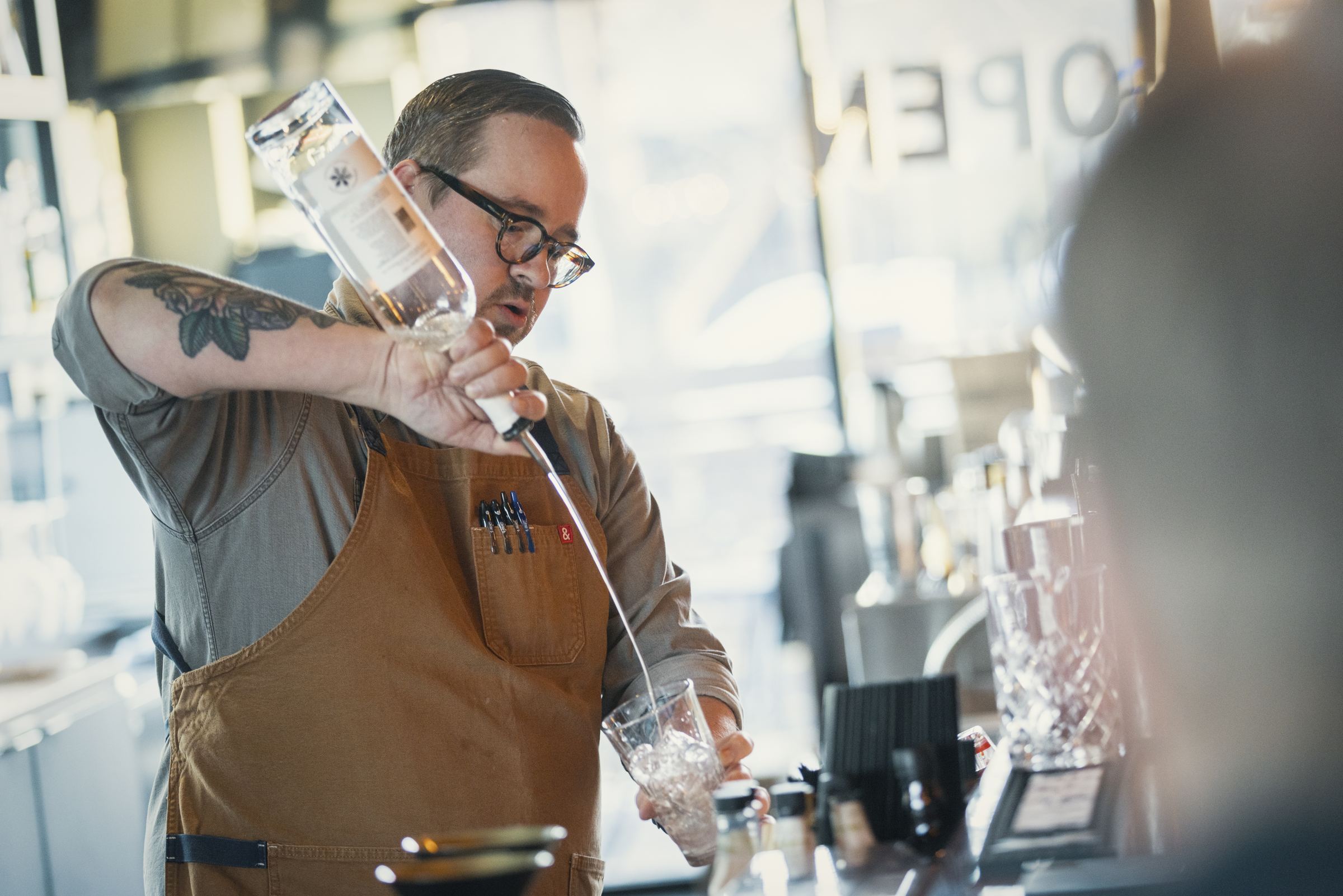 Bartender pouring a drink at the service well