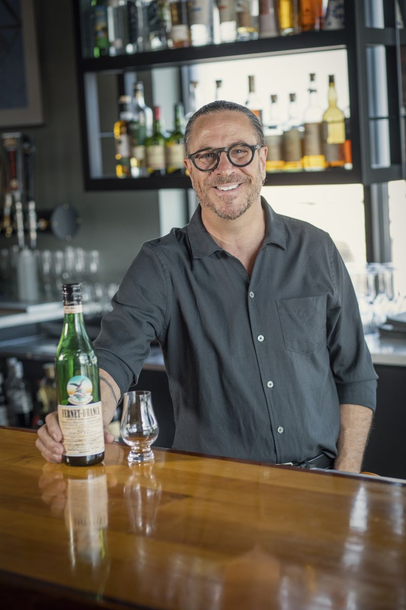 Brian Tessari smiling behind the bar at Domenic’s