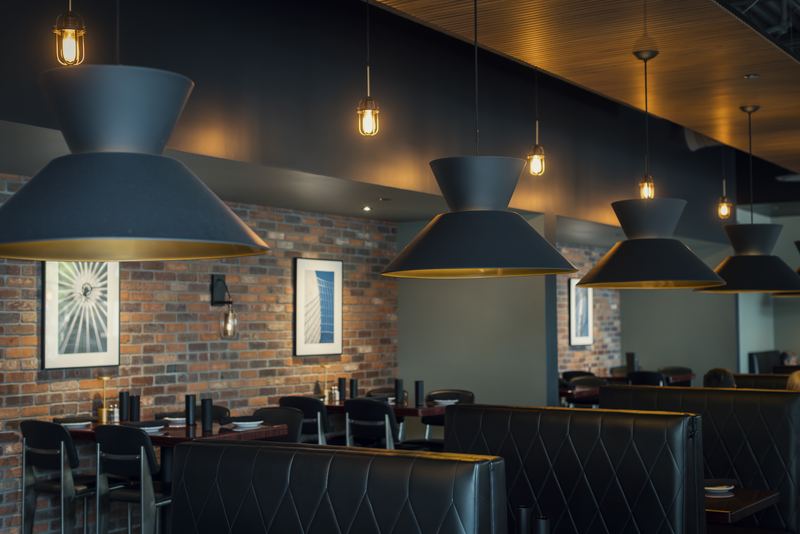 The Domenic’s dining room with pendant lights and a brick wall