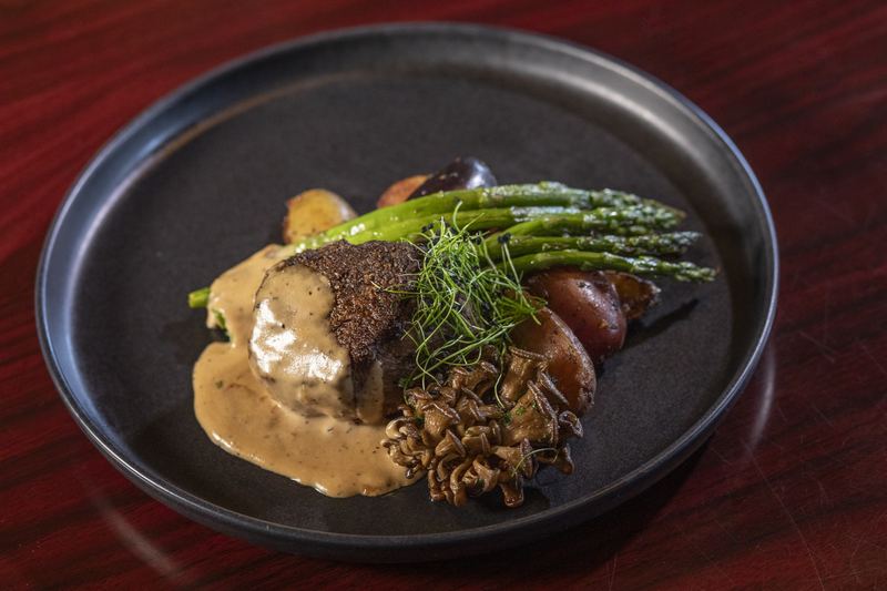 A plated steak with asparagus and mushrooms