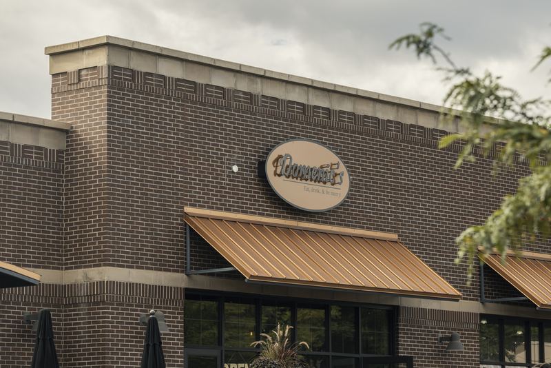 The brick exterior and sign of Domenic’s Bistro & Wine Bar