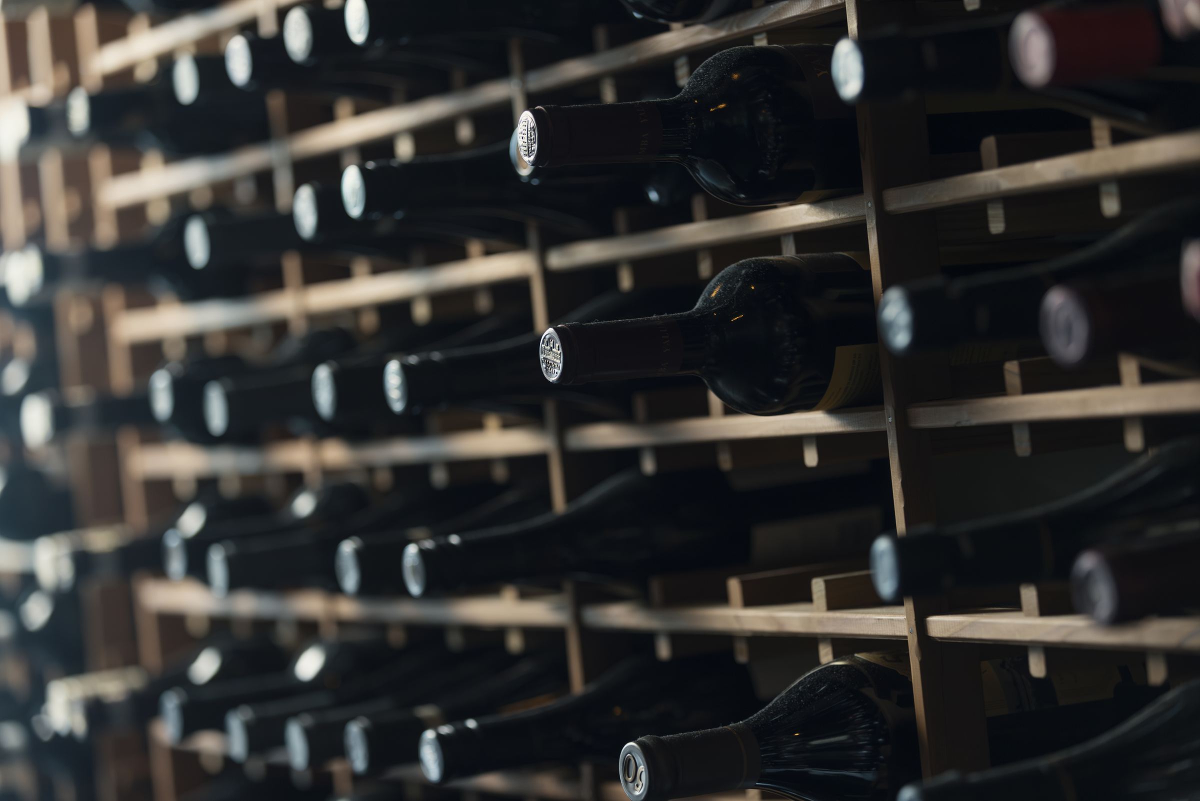 Wine bottles resting in the cellar racks